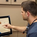 Dr. Wilson examining dental images on a monitor