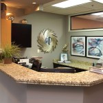 Modern reception area with curved granite countertop desk and warm lighting
