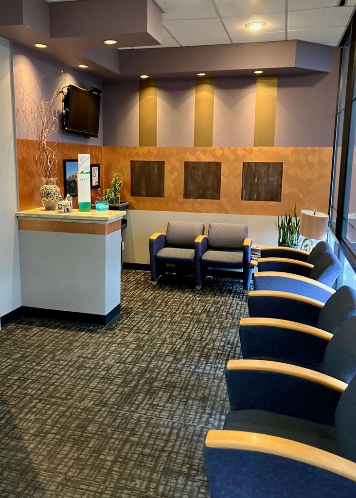Comfortable waiting room with blue upholstered chairs and carpeted flooring